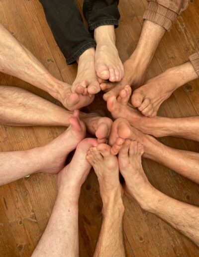 Pieds réunis en cercle sur un parquet.