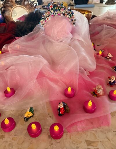 Voiles roses, couronne, bougies et petites figurines.